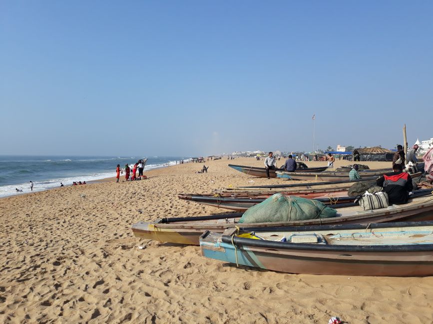 Fishing boats lined up on Puri Beach at sunset with the tide going out