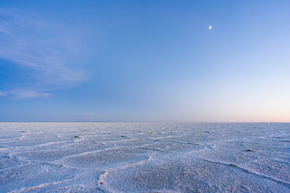 A full moon rising over the glowing white salt flats of the Rann of Kutch