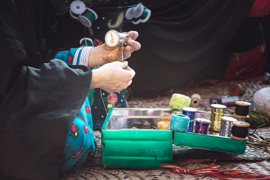 A Rabari craftswoman in Kutch embroidering intricate mirror-work onto cloth