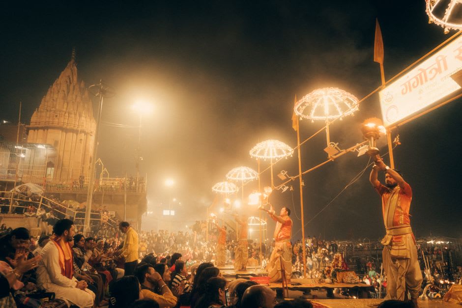 Pilgrims performing evening rituals by lantern light at Triveni Ghat near Somnath