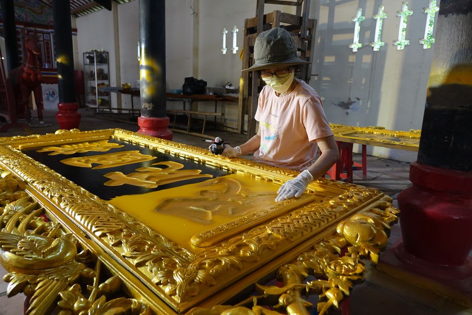 Artisan applying gold leaf to a traditional Thanjavur painting of a Hindu deity