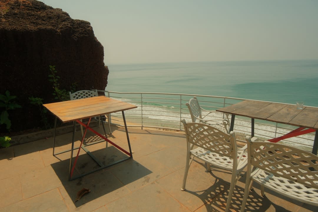 Cliffside cafes strung with lights above Varkala's red laterite cliffs at dusk