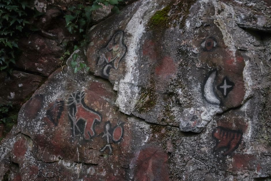 Ancient petroglyphs carved into the rock walls inside Edakkal Caves in Wayanad