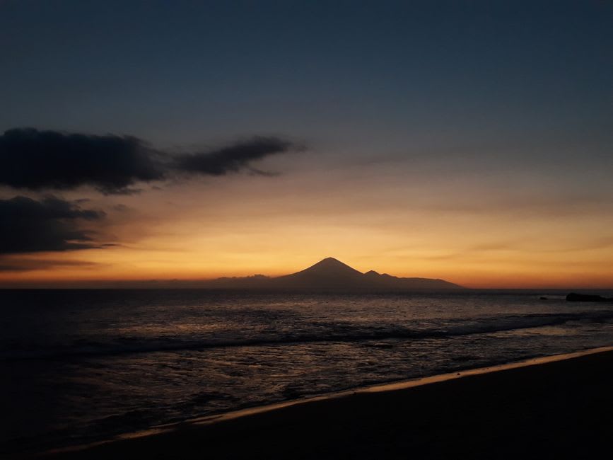 Sunset over Mount Agung silhouette seen from a Gili Meno beach