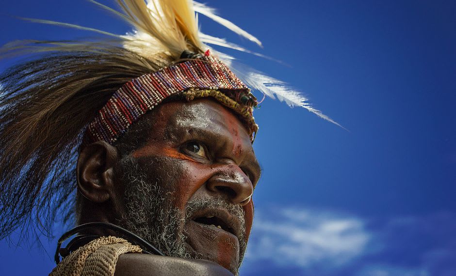 Dani men in traditional dress with feathered headdresses at a highland gathering