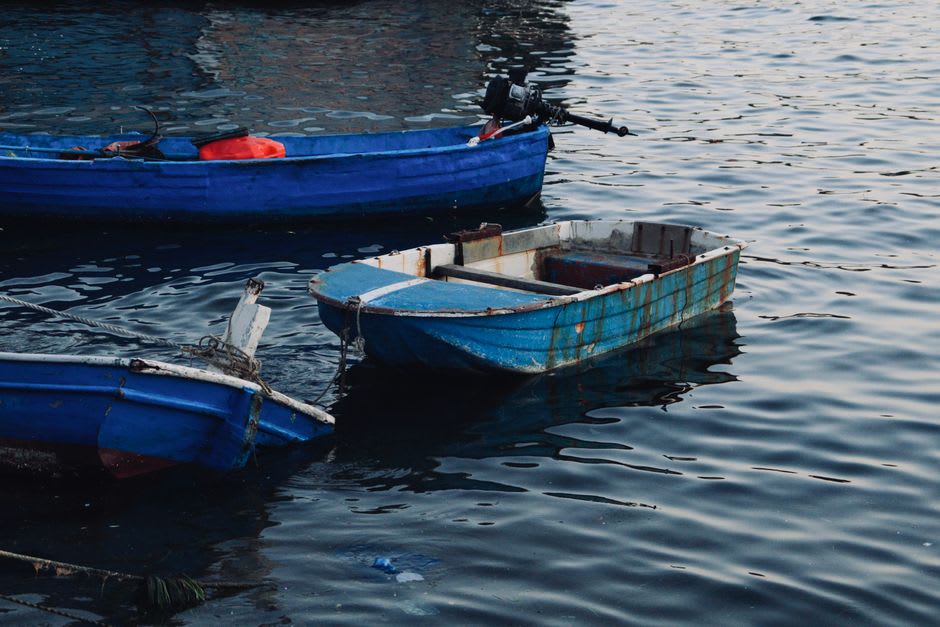 Fishing canoes crossing the calm blue water of Jayapura's harbor bay