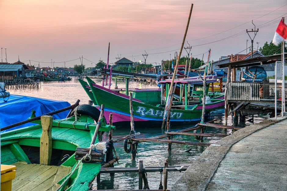 Colorful wooden fishing boats docked at the harbor in Kendari at sunset