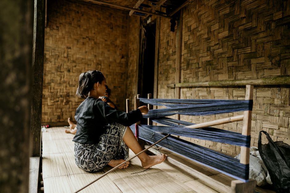 Interior of a traditional Mentawai uma longhouse with woven walls and hanging tools