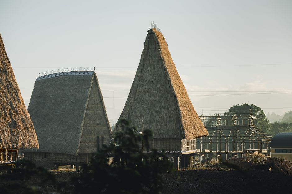 Wooden traditional houses with steep thatched roofs in a hilltop Nias village