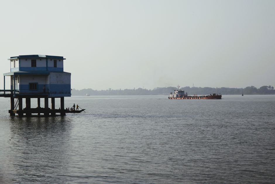 The Musi River at dusk with fishing boats and stilted houses along the bank in Palembang