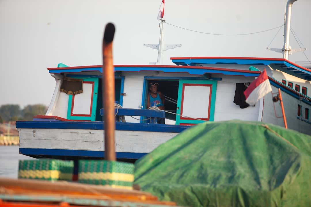 Fishing boats returning to shore at dawn with the morning catch at Pangandaran's harbor