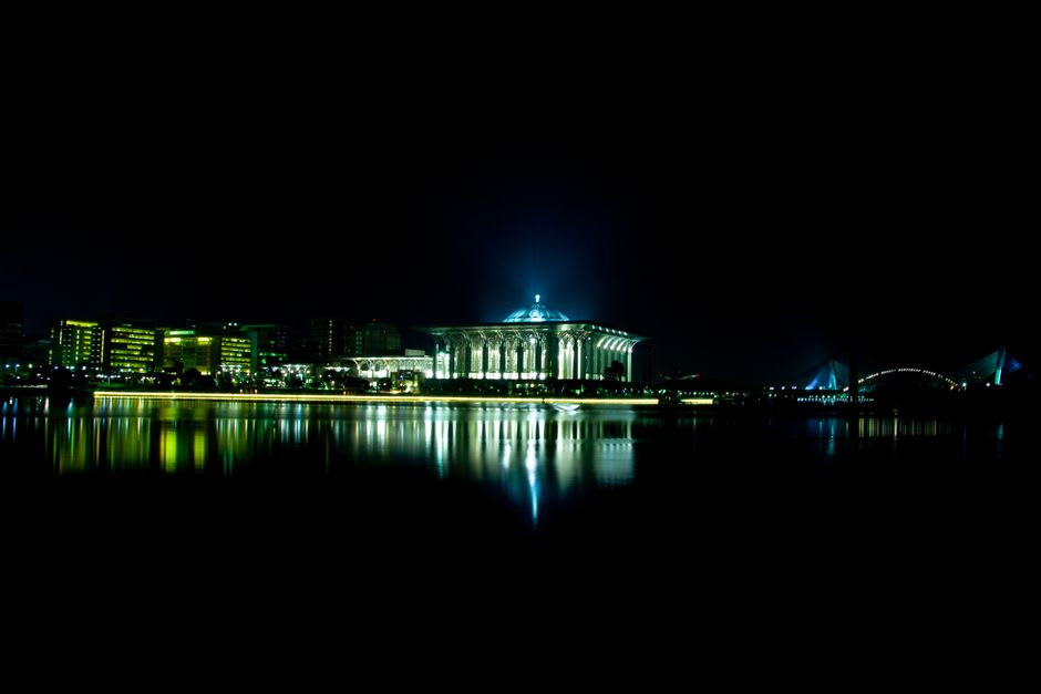 The illuminated domes and minarets of the Islamic Center Samarinda reflected on the Mahakam River at night