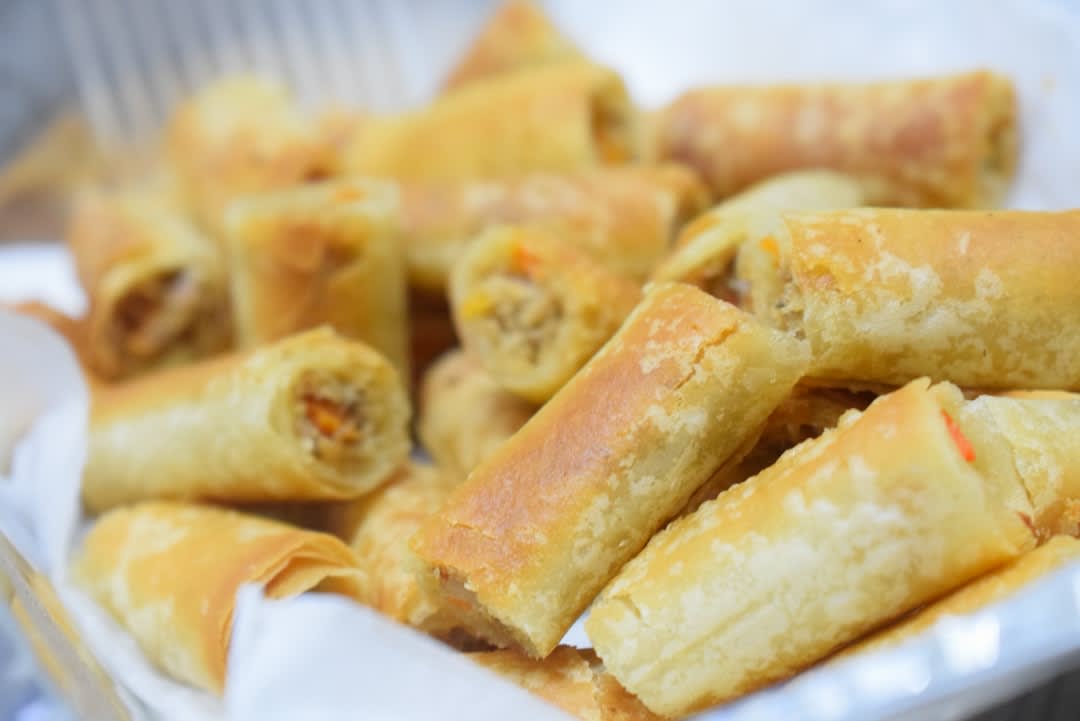 Freshly fried lumpia semarang spring rolls served with dipping sauce and cucumber