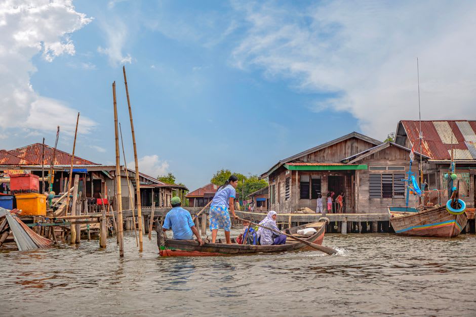 Wooden stilt houses built over turquoise water in a Bajau fishing village