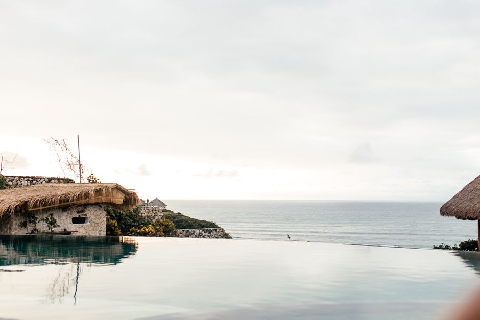 Infinity pool on a clifftop terrace overlooking the ocean at golden hour