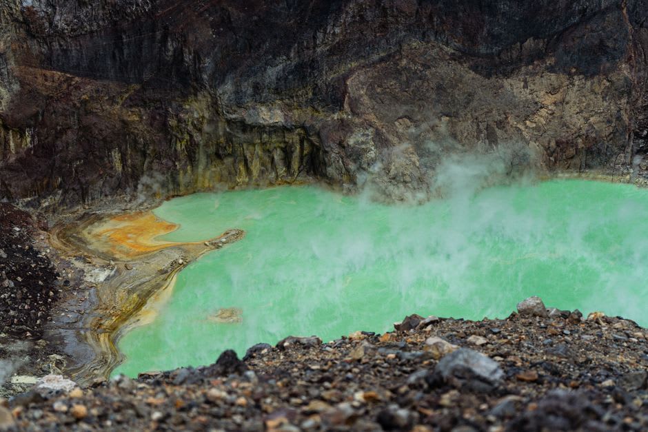 Colorful sulfuric lake surrounded by pine forest on the Dieng Plateau