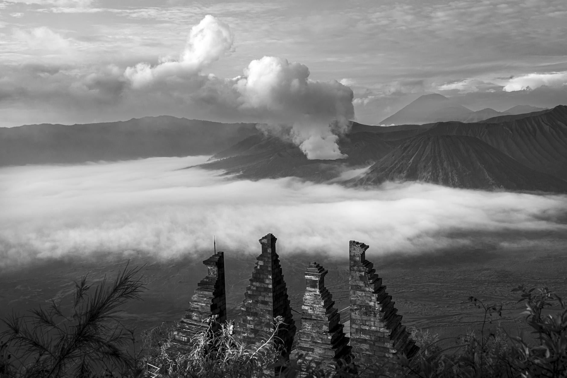 Misty volcanic peaks rising above tropical forests in Java