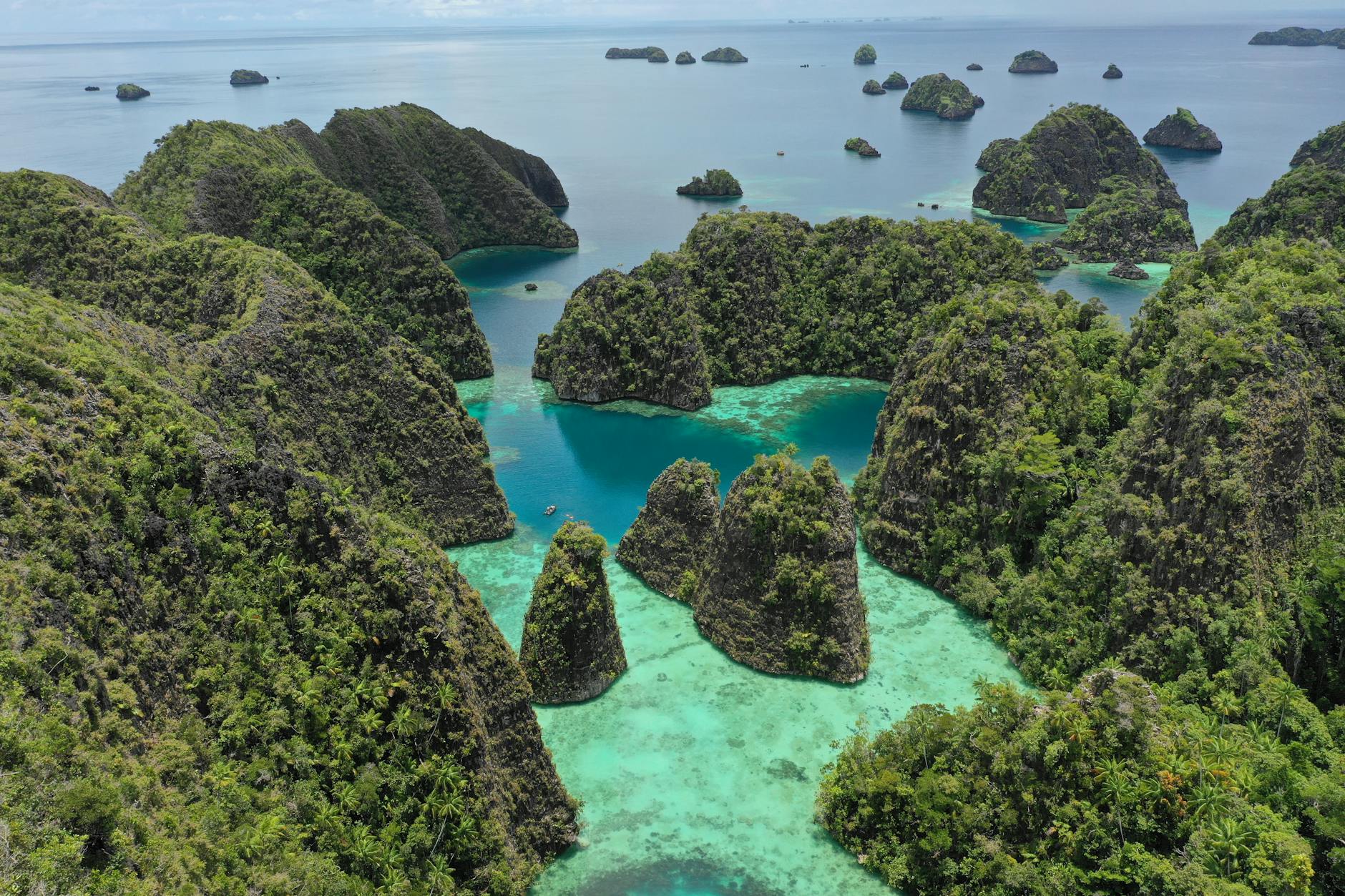 Crystal clear tropical waters with lush green islands in the distance