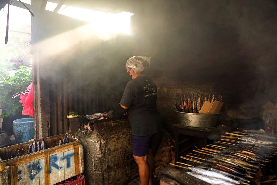 Grilled fish and satay served at a beachfront warung along the Lovina promenade at sunset