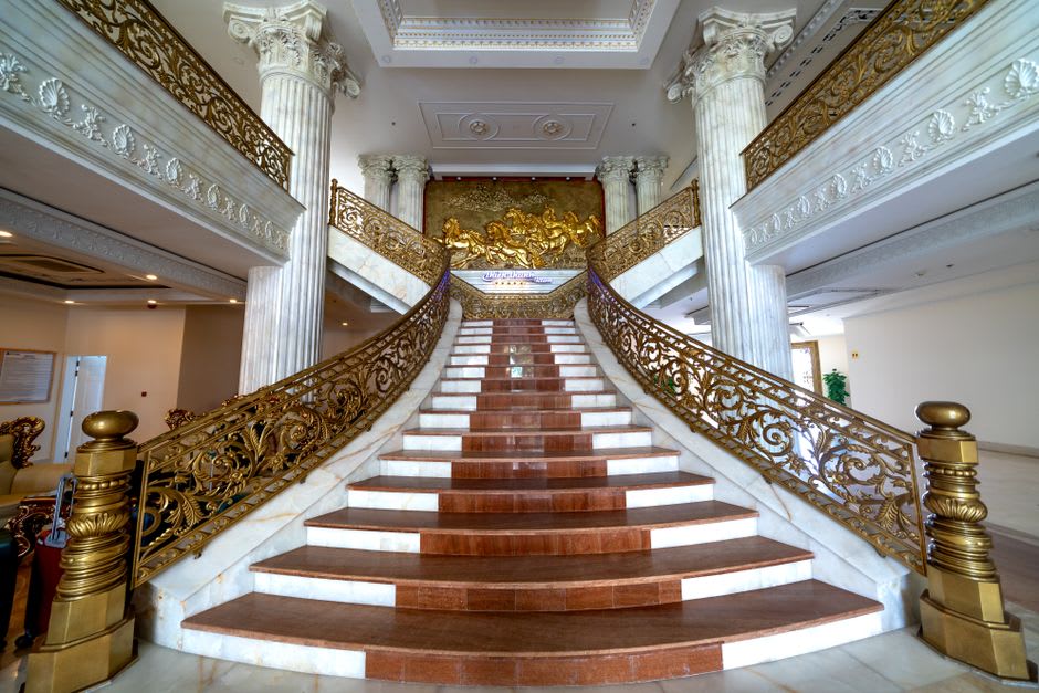Interior wooden staircase and gold songket textiles inside the Pagaruyung palace