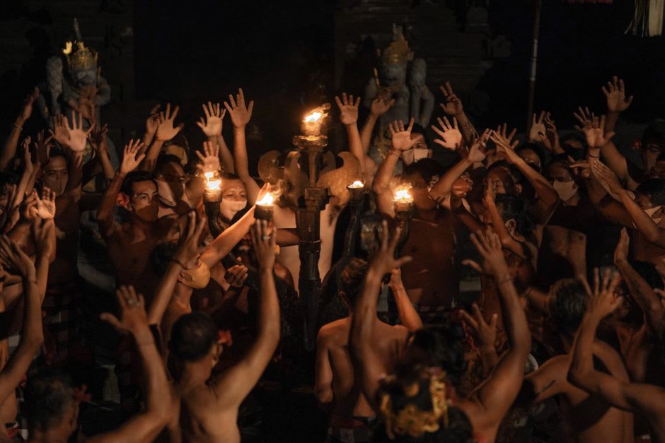Traditional Minangkabau plate dance performance with dancers holding lit candles