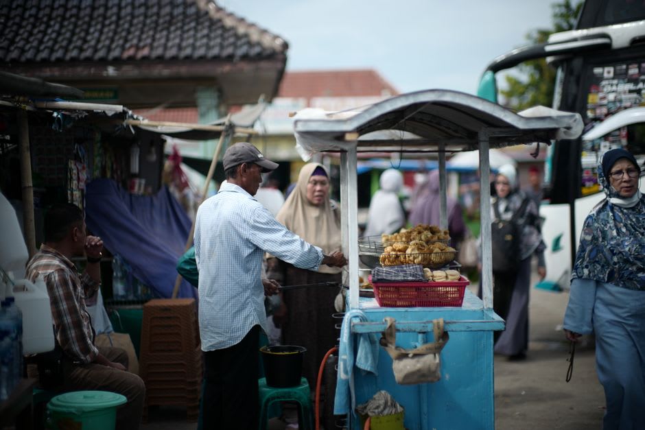 Vendor preparing choipan dumplings at a street food stall in Pontianak