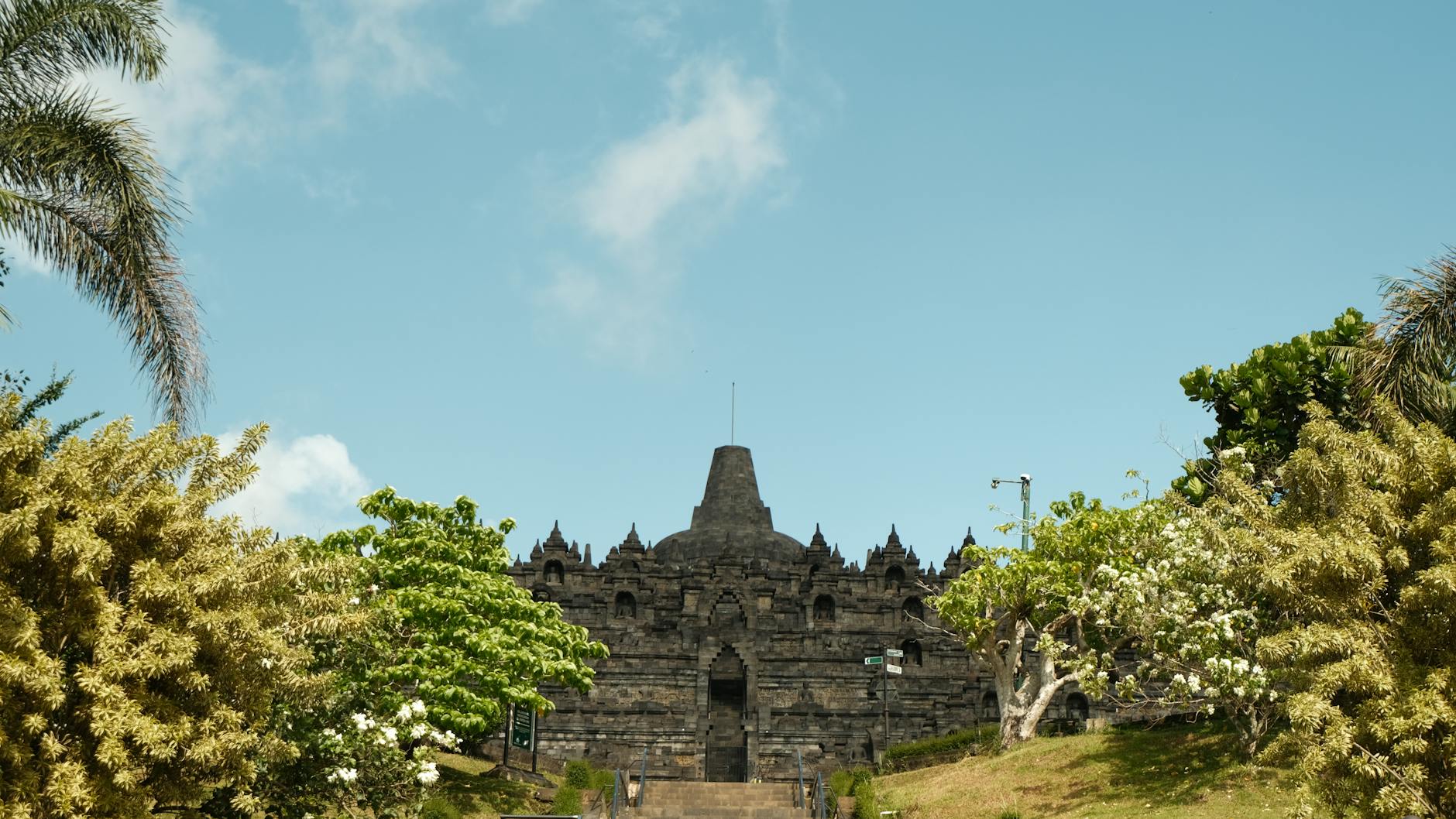 Ornate Javanese temple architecture surrounded by tropical greenery