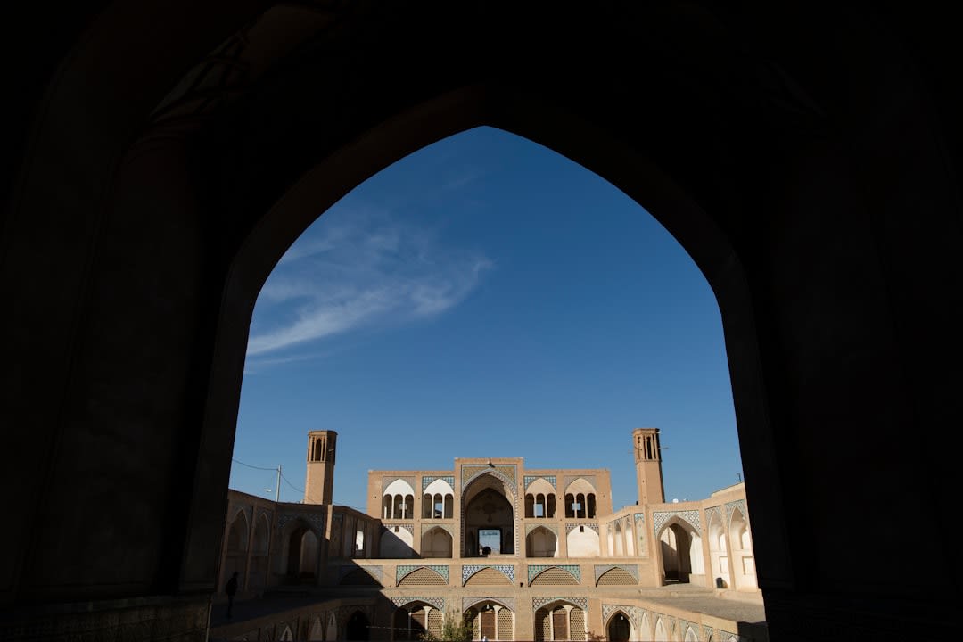 Staircase descending into the sunken central courtyard of Agha Bozorg Mosque, with the tall symmetrical iwan visible above