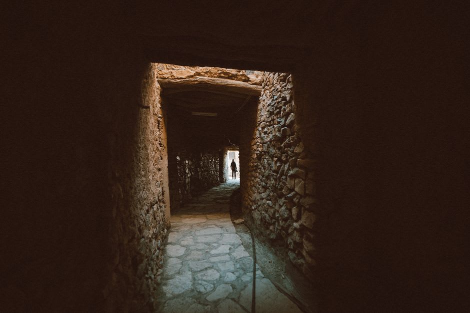 The interior of a centuries-old rock-carved home in Kandovan with curved tuff walls and a small hearth