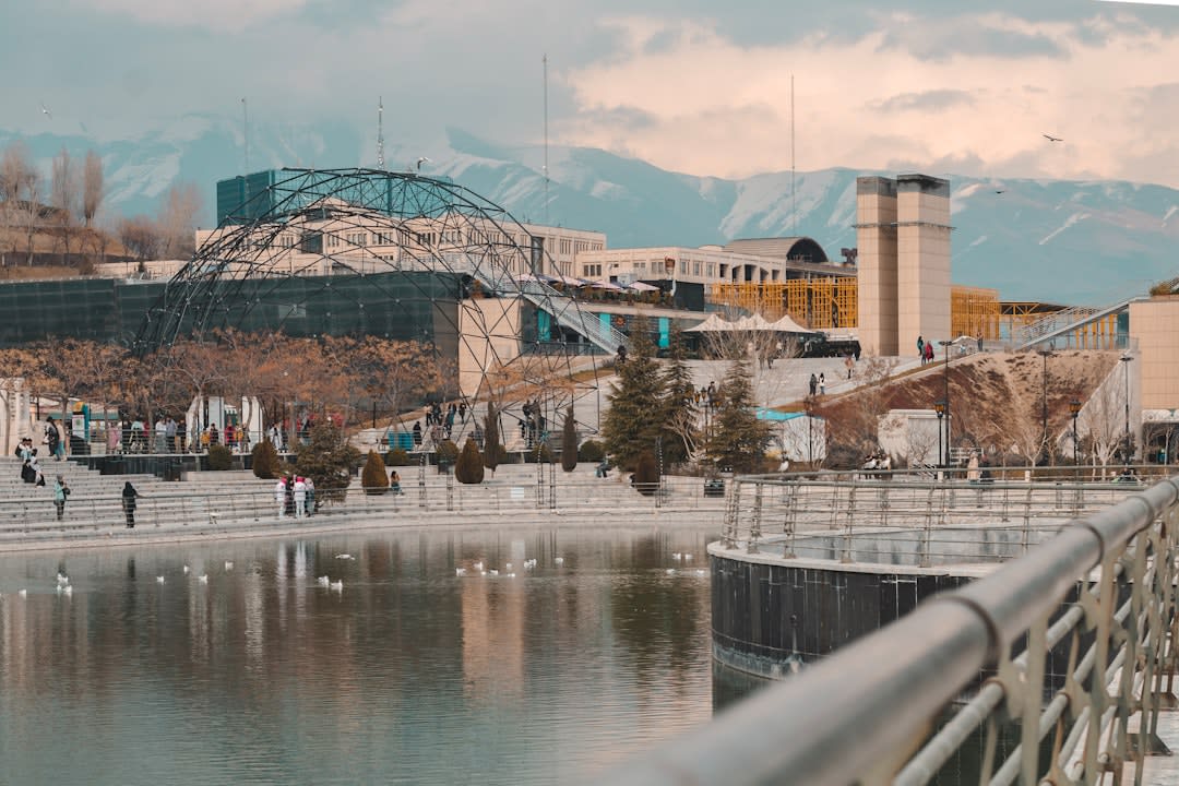 Pedestrians walking across the multi-level timber decking of Tabiat Bridge