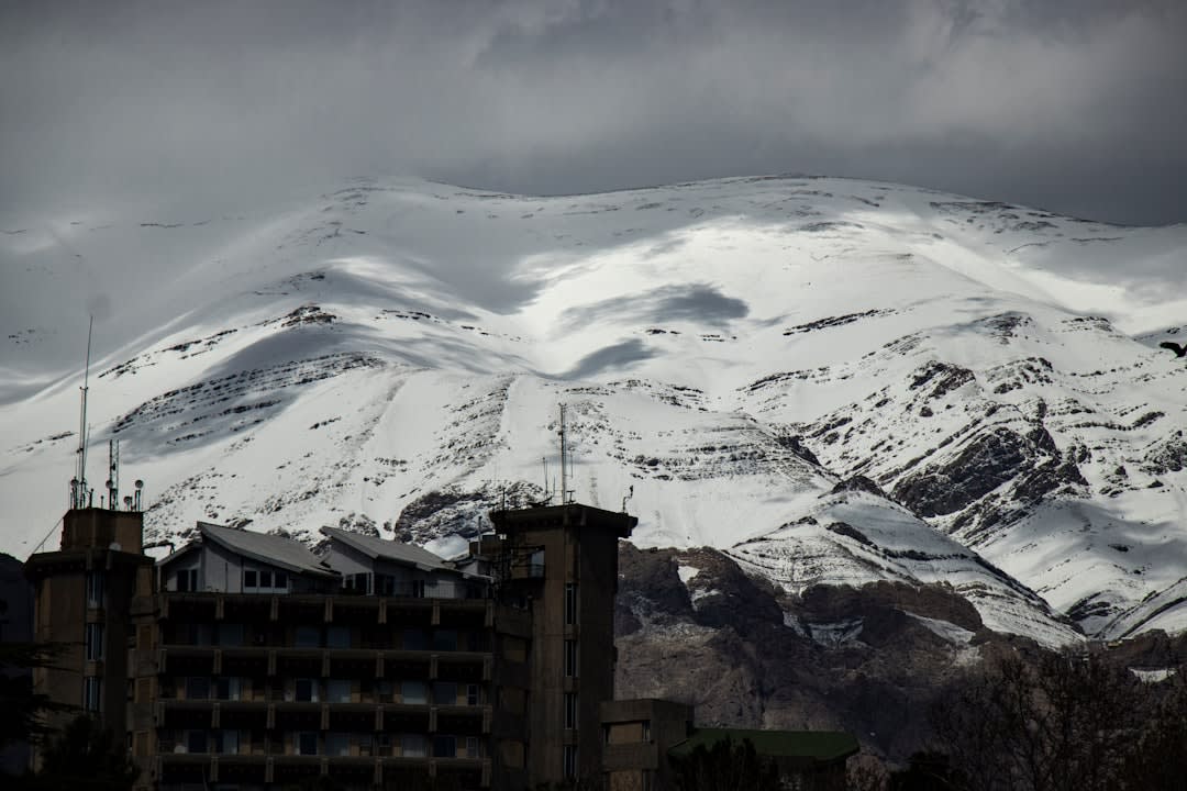 Cable car ascending steep rocky terrain on Tochal mountain above Tehran