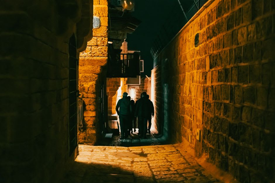 Callejón estrecho de piedra arenisca en la vieja Jaffa con arcos y buganvillas colgantes