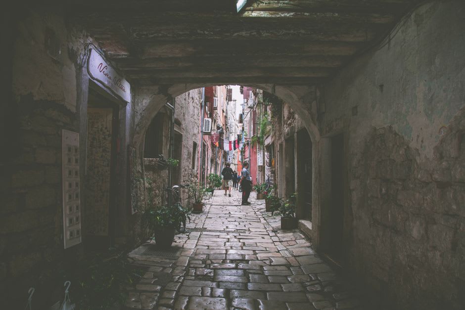 Sunlit stone alley in Bale's old town lined with weathered facades