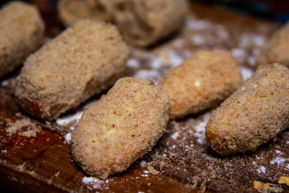 Golden fried olive all'ascolana served on a plate with local wine