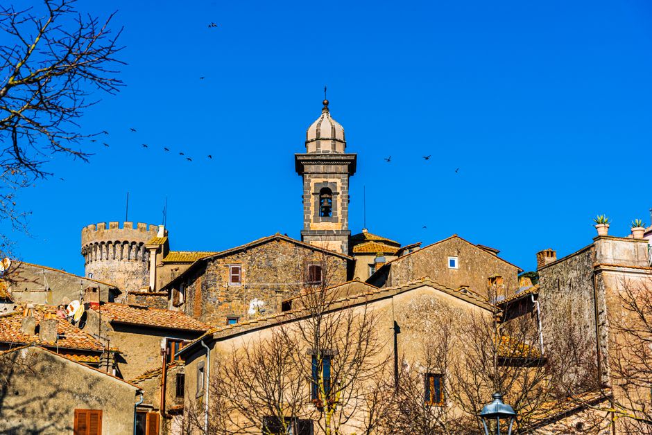 The crenellated stone towers of Castello Orsini-Odescalchi rising above the lakeside town of Bracciano