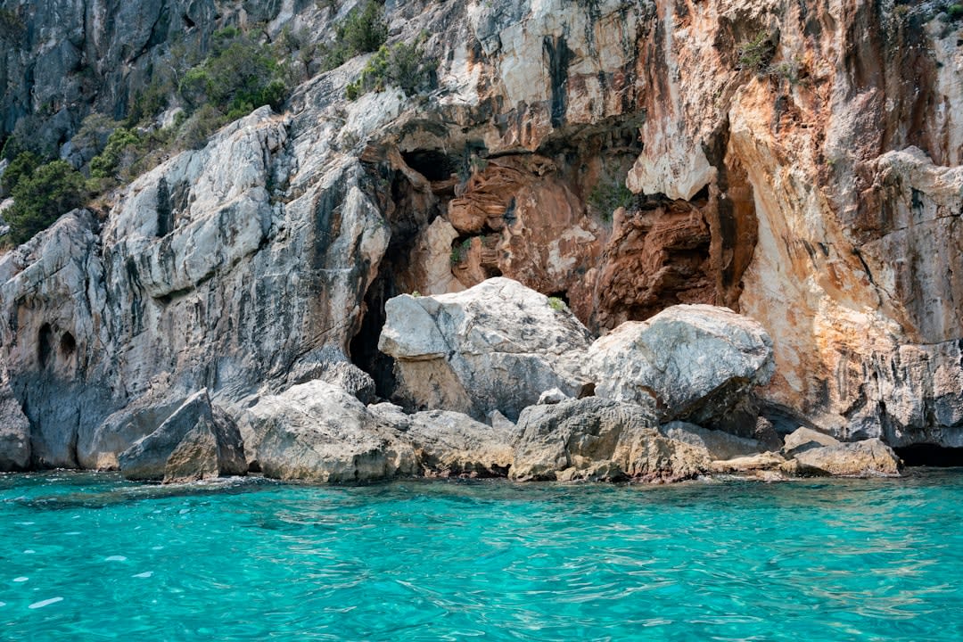 Rounded pink granite boulders framing a turquoise cove near Capriccioli on the Costa Smeralda