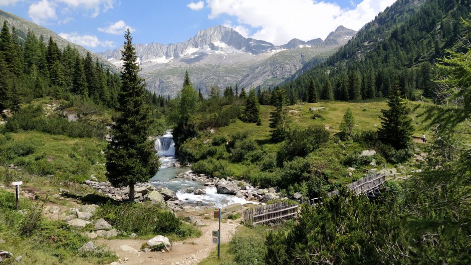Hikers on a trail in the Val Ferret with the Grandes Jorasses towering in the background