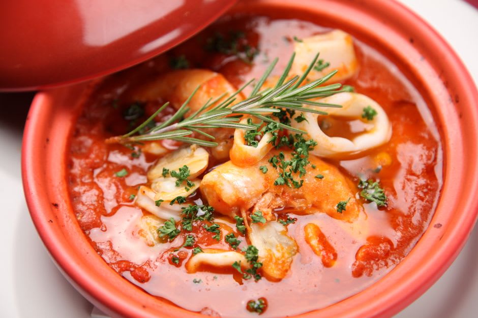 A bowl of brodetto fish stew with grilled bread at a trattoria near Fano's harbor