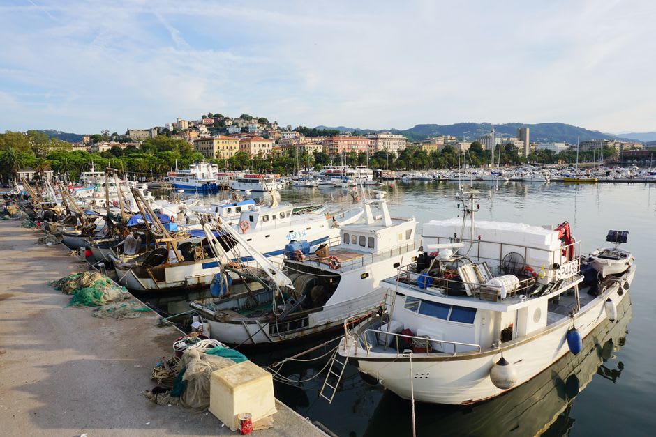 The palm-lined waterfront promenade of La Spezia at dusk