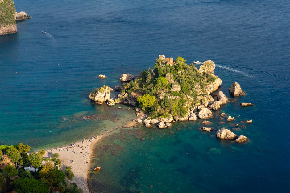 The turquoise water and rocky sandbar of Isola Bella below Taormina