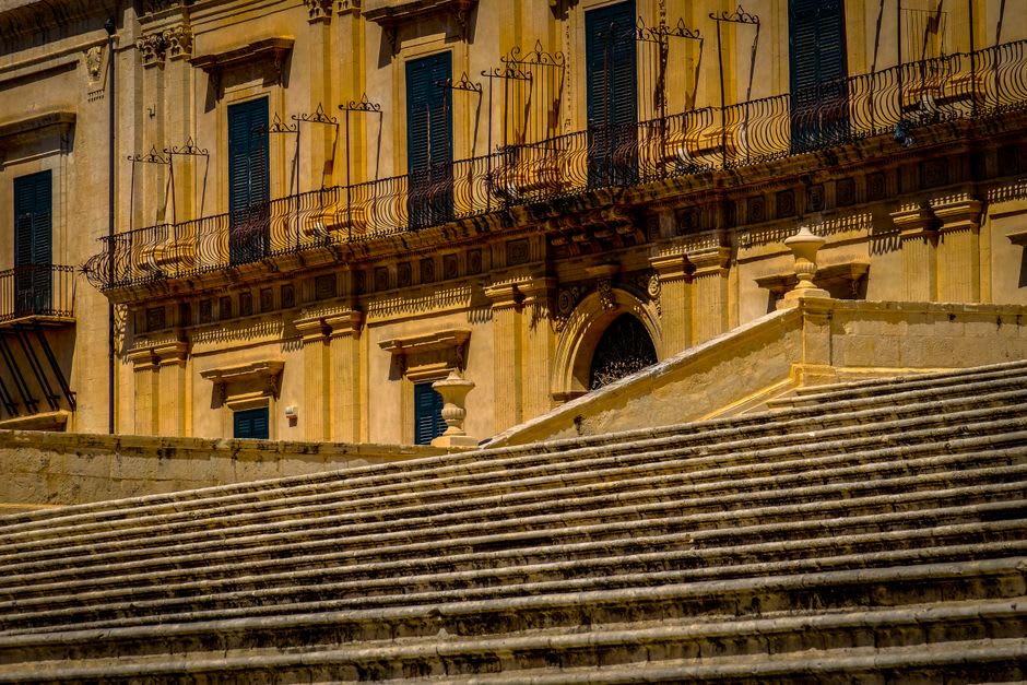 Ornate carved stone balconies on Palazzo Nicolaci supported by grotesque figures