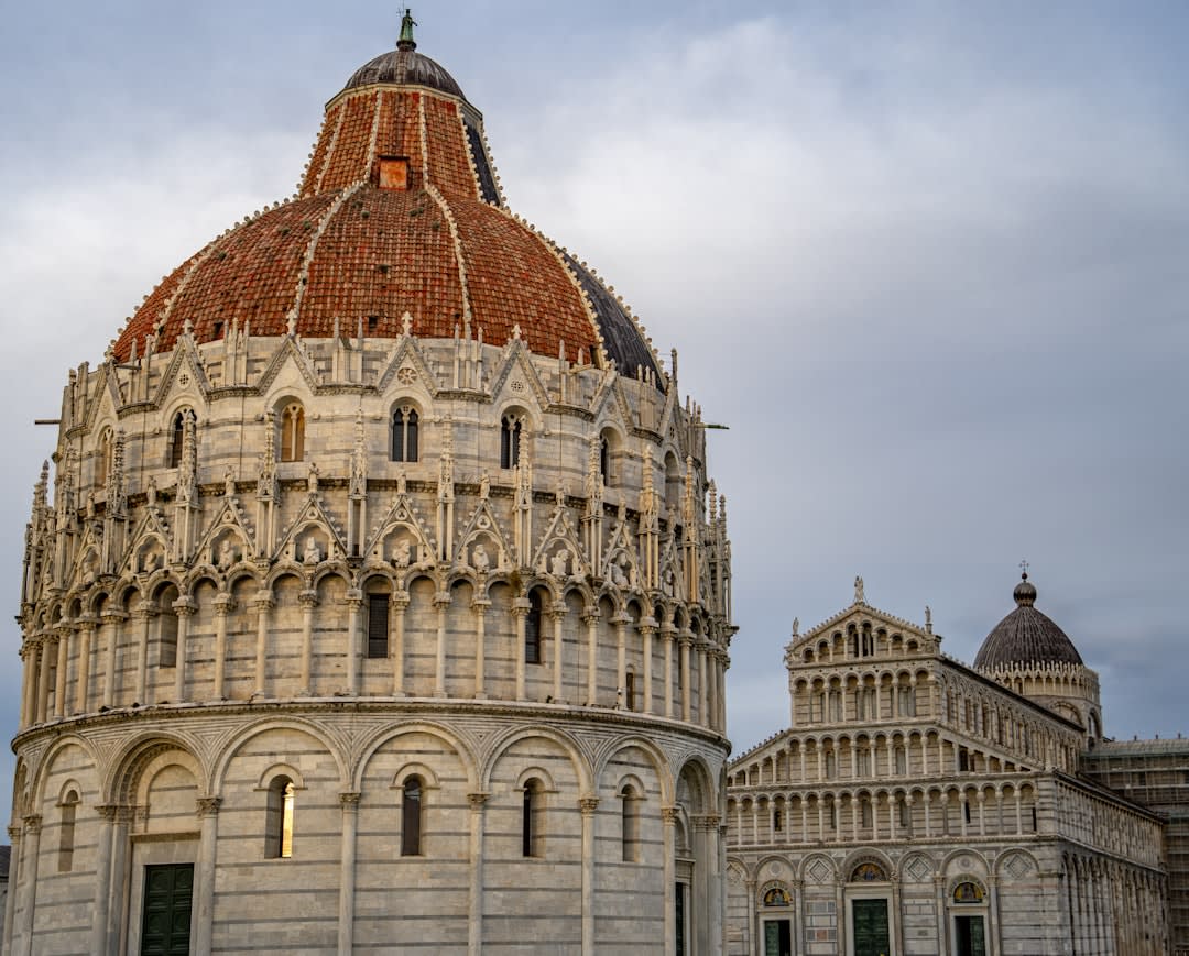 The white marble facade of Pisa's cathedral and baptistery on the Field of Miracles