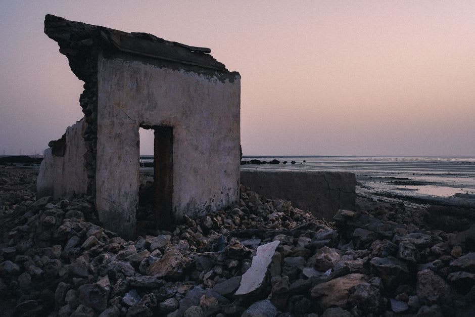 Ruined colonial-era building half-submerged by the encroaching Atlantic at Vieux Lahou