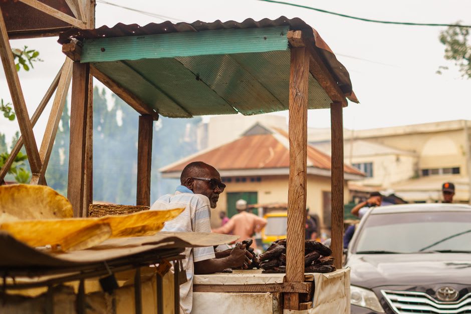 Dusty market street in Odienné with vendors under improvised awnings