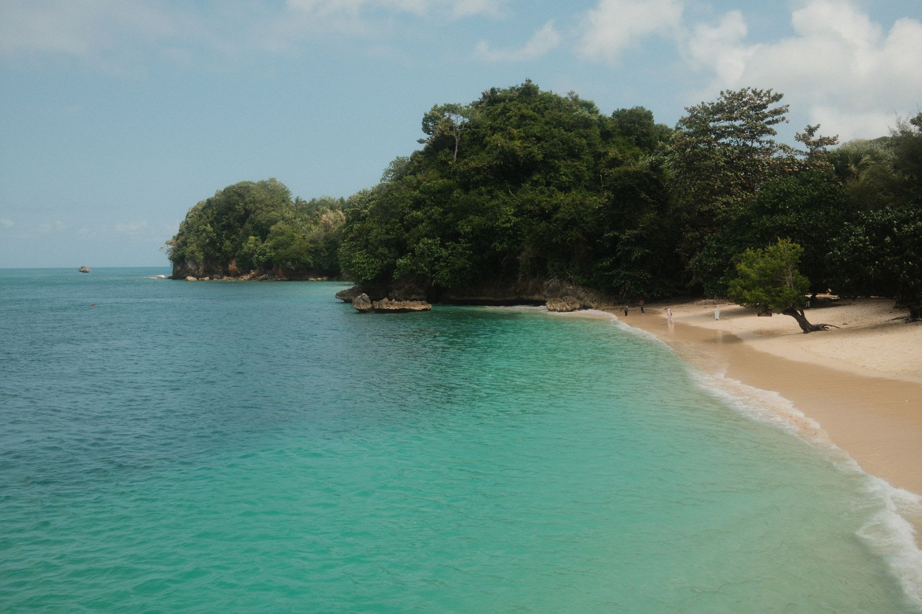 Boston Bay beach near Port Antonio, the birthplace of Jamaican jerk — pimento wood pits smoking under palm trees on a grey morning
