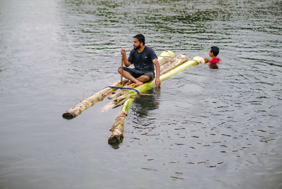 Bamboo raft captain poling down a shaded stretch of the Rio Grande in Portland, Jamaica