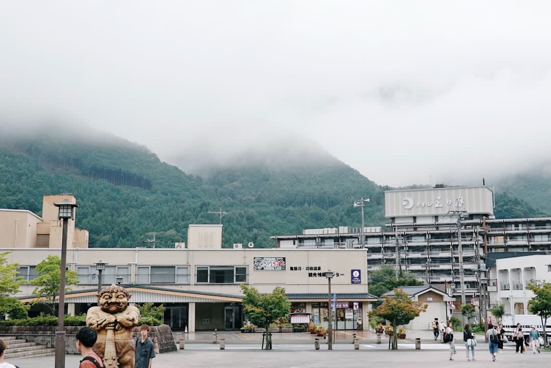 A nostalgic Shōwa-era kissaten coffee house in Atami with velvet chairs and a tall glass of green cream soda on a marble-topped table