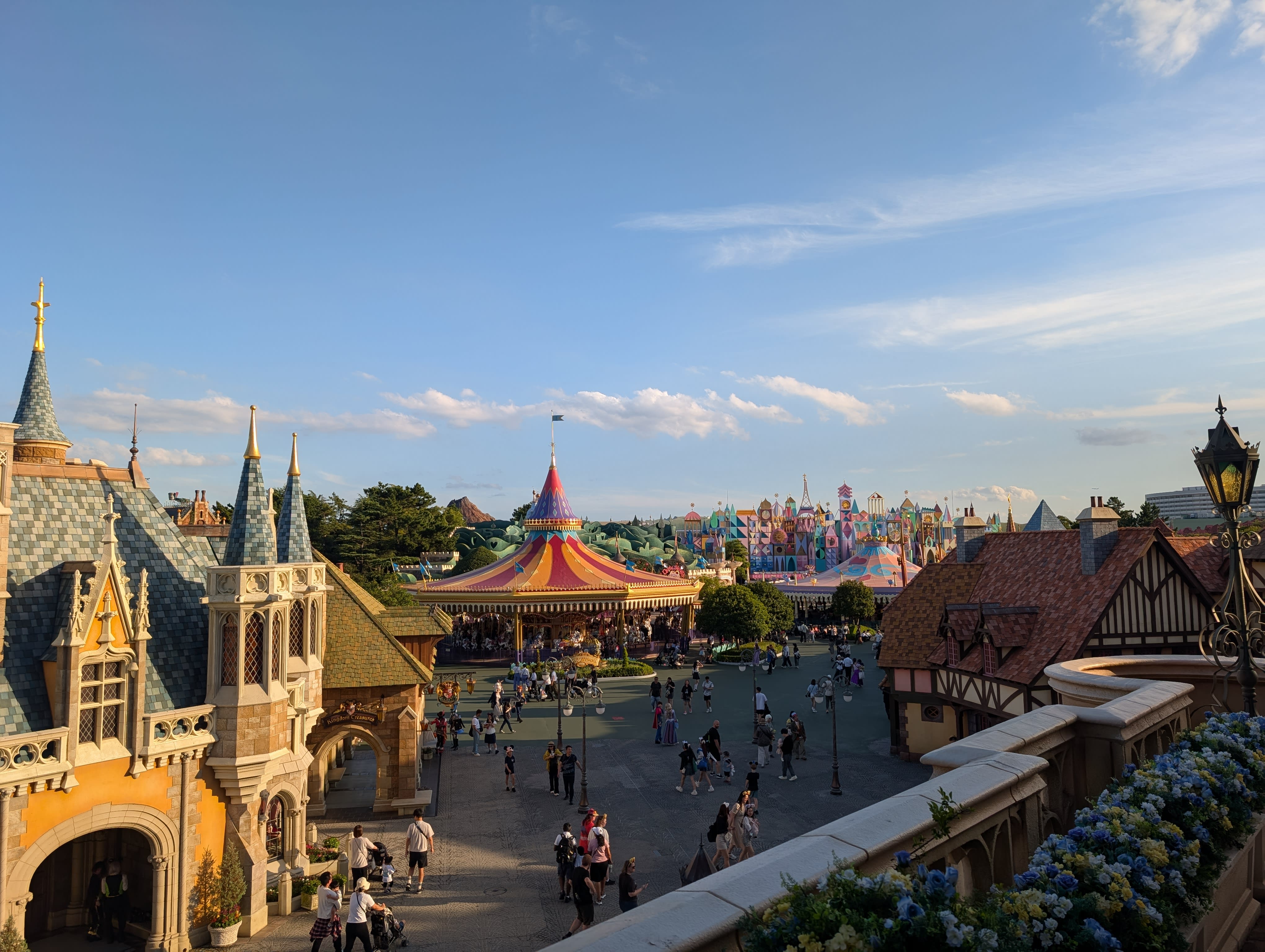 The view from inside Cinderella Castle — Fantasyland stretching to the horizon, the carousel and colourful rooftops under a late-afternoon sky
