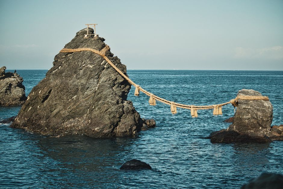 Meoto Iwa, the wedded rocks at Futami near Ise, two sea stacks joined by a thick straw rope standing in the ocean under a pale morning sky