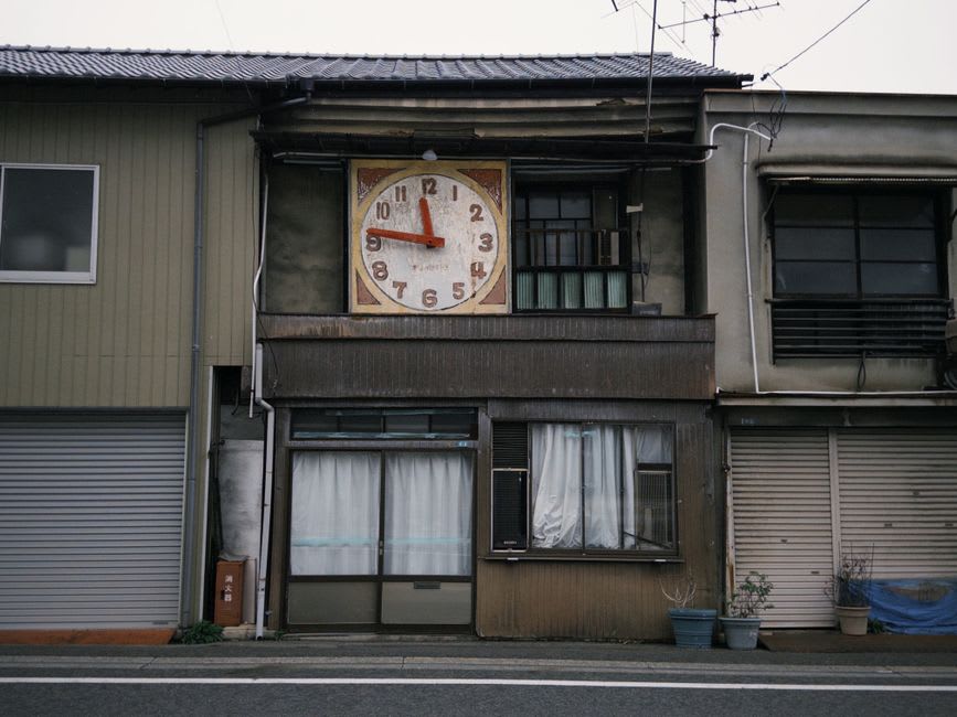 The Shinkoro clock tower on its wooden frame against a pale afternoon sky